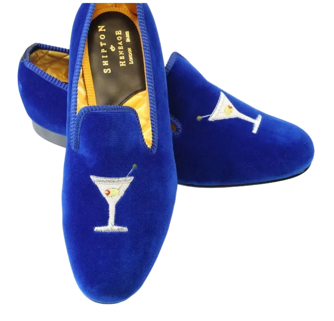 Blue velvet slippers with martini glass embroidery on a white background